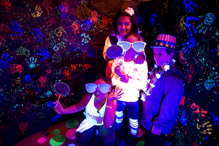 Students in Blacklight photo booth